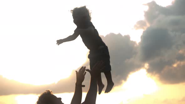 Silhouette of a Father Playfully Throwing His Son in the Air