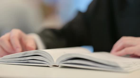 Woman Reading Book with Hand Gesture Close Up