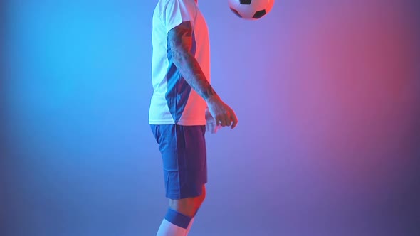 Male Soccer Football Player Juggling Ball on Legs in Studio