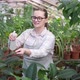 Woman Sprays Green Plant with Large Leaves with Water From Spray Bottle - VideoHive Item for Sale