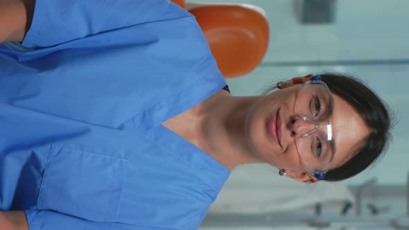 Vertical Video Nurse Smiling at Camera Sitting in Dental Office