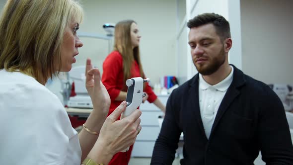 Doctor checking eyes with device. Female doctor examining eye with medical equipment