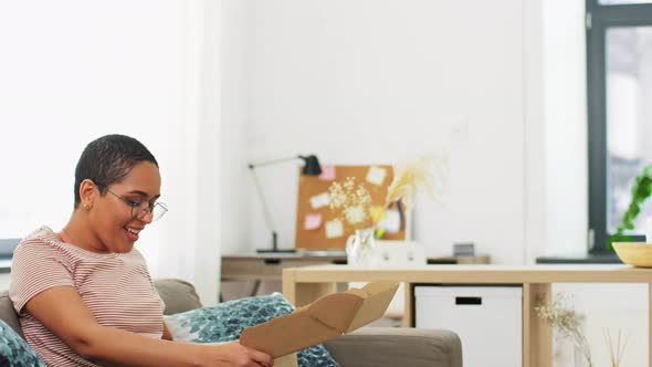 African American Woman Opening Parcel Box at Home