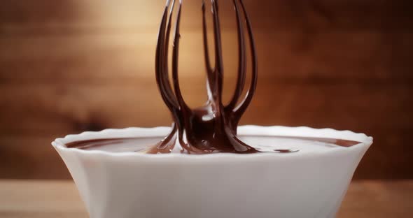 Closeup Mixing Melted Liquid Chocolate with Steel Whisk in Kitchen