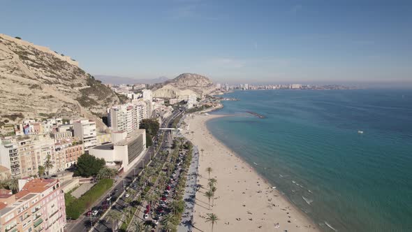 Aerial backwards view over a beautiful beach in Alicante, Spain. Real time