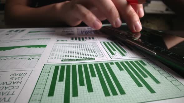 Accountant Analyzing Business Marketing Data on Paper Dashboard at Office Table