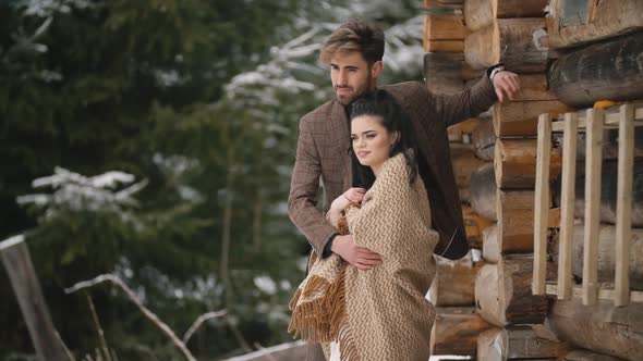 Couple Near a Wooden House