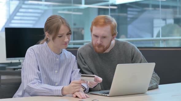 Young Man and Woman Making Online Payment on Laptop