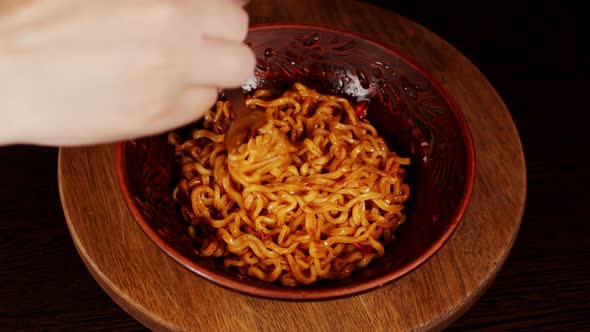 Readymade Instant Noodles with Condiment and Spicy Sauce in Plate on Wooden Board