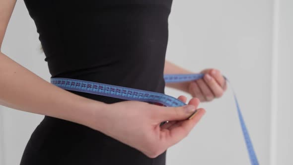 Closeup of Fit Woman Measuring Waist