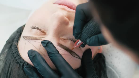 Cosmetologist Making Eyebrow Permanent Makeup