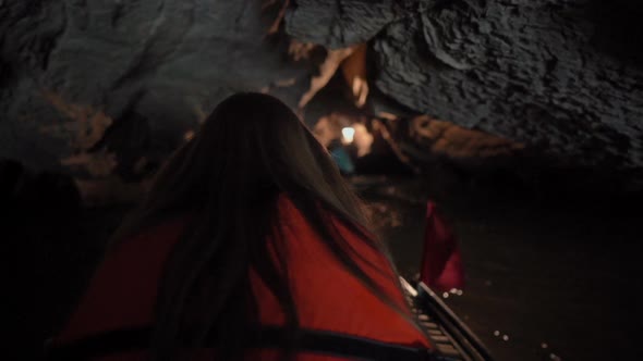 Slowmotion Shot of a Young Woman on a Boat Having a River Trip Through Rocks in Ninh Binh a Tourist