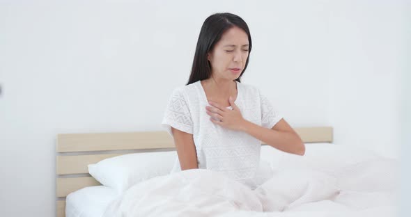Woman feeling back pain and tired on bed 