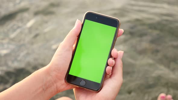 NICE, FRANCE - JULY 2017 Modern green screen display phone in woman hands