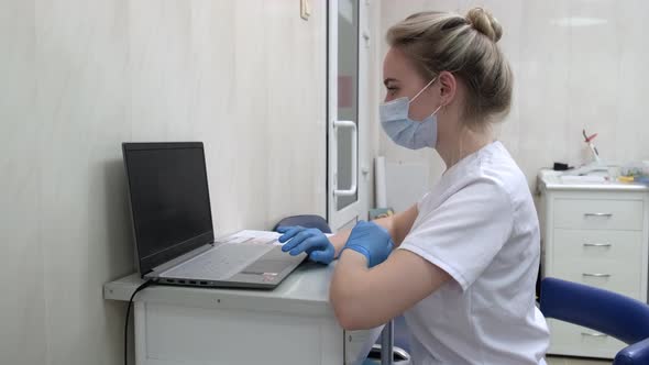 Young Doctor or Nurse Working on Laptop Computer in Hospital