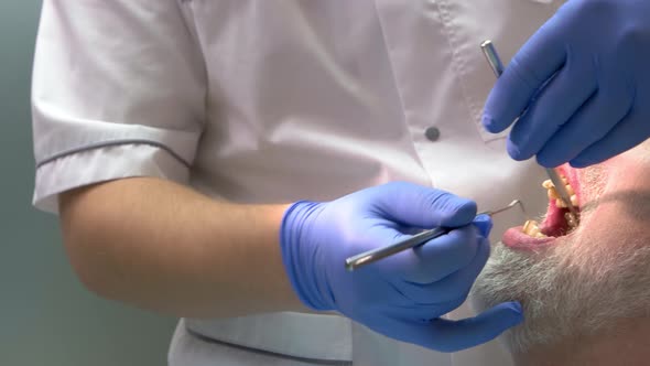 Male Dentist in Gloves Working.