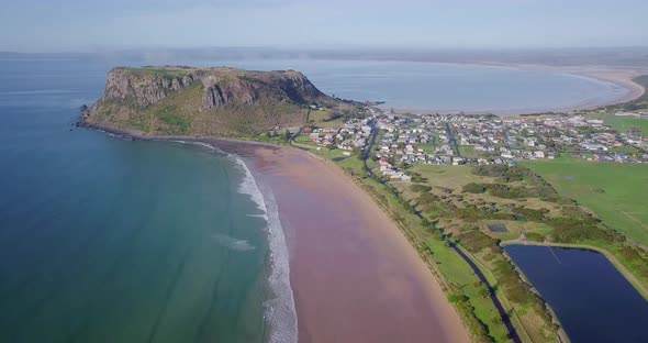 Ascending aerial flight over Stanley towards a huge rock in Tasmania, Australia