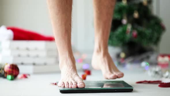 Close-up of male legs stand on the scales measure weight.