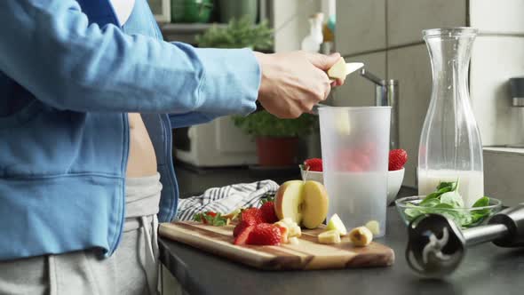 Woman cutting fresh fruit in the kitchen