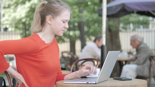 Young Businesswoman with Back Pain Working on Laptop Outdoor