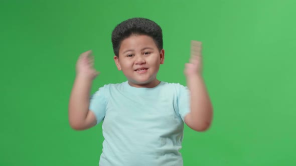 The Portrait Of A Asian Little Boy Opening His Eyes With Palms In The Green Screen Studio