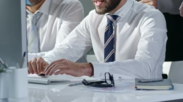 Business Partners Typing on Computer at Desk