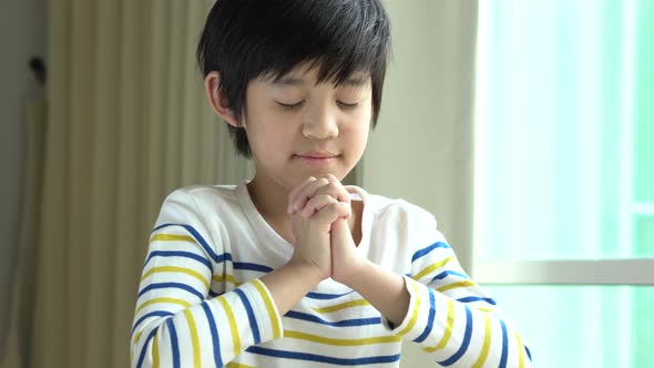 Cute Asian Child Boy Praying With Eyes Closed In The Morning