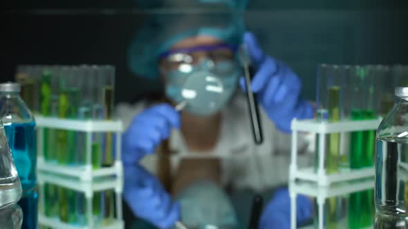 Scientist Looking at Black Substance in Tube With Magnifying Glass, Examination