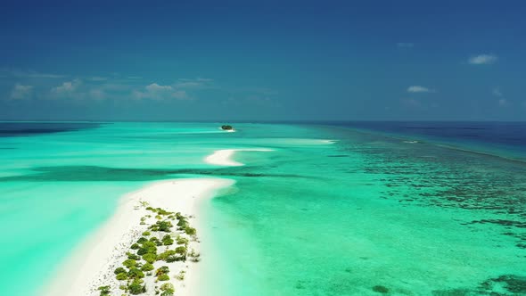 Flying over a sandbanks and uninhabited islands in Turquoise green water in Maldives