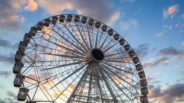 Ferris wheel silhouette at sunset - time lapse - against beautiful clouds in the sky