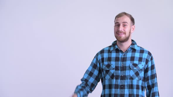 Happy Bearded Hipster Man Pointing Up and Looking Surprised