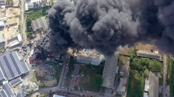 Aerial overhead shot of burning warehouse black smoke coming out