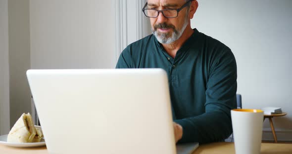 Man using laptop in living room 4k