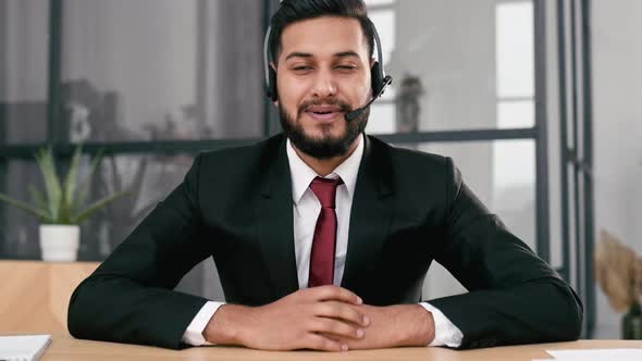 Attractive Young Indian or Arabian Businessman Financial Advisor Sit at Desk in Modern Office Having