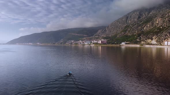 Aerial Footage of Motorboat Swimming in Egirdir Lake to the Coast Where There is a Town