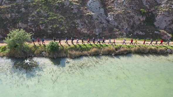 Group Of People Trekking By The Lake On Aerial View