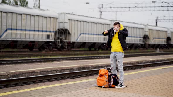 Man in Medical Mask Stands on Platform Waiting for Train