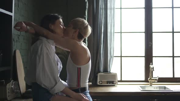 Portrait of Young European Lesbian Couple Is Kissing and Hugging in Modern Apartment Spbd.