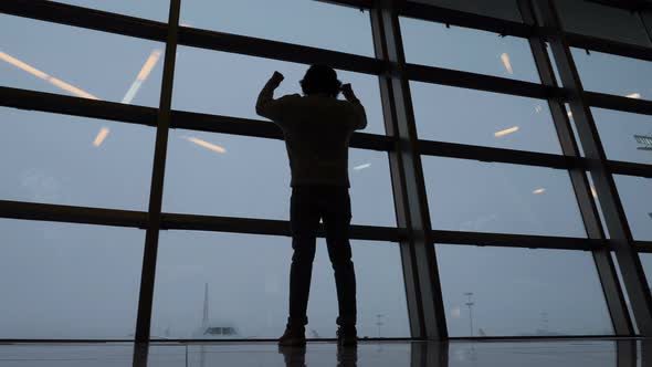 Silhouette of Excited Man Celebrating Success at Airport