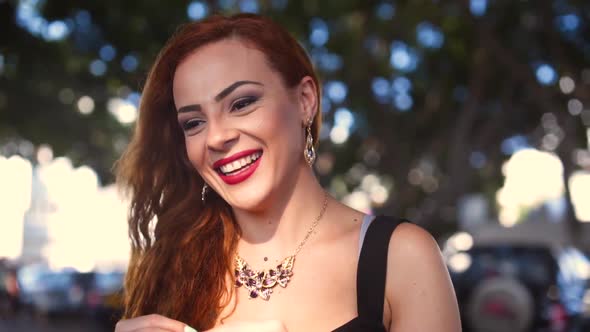 Portrait of Young Smiling Redhead Woman with Black Eyes