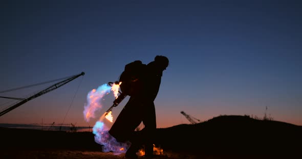 A Man with a Flamethrower at Sunset in Slow Motion