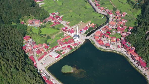 aerial close up of a mountain village in Uzungol Trabzon full of homes with red roofs and a mosque a