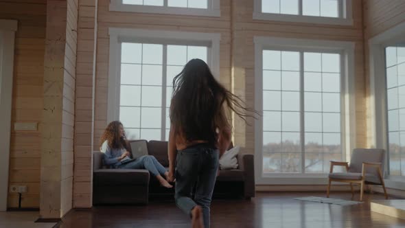 Children Run to Mom Working at the Laptop From Home and Hug Her on a Couch