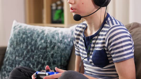 Boy with Gamepad Playing Video Game at Home