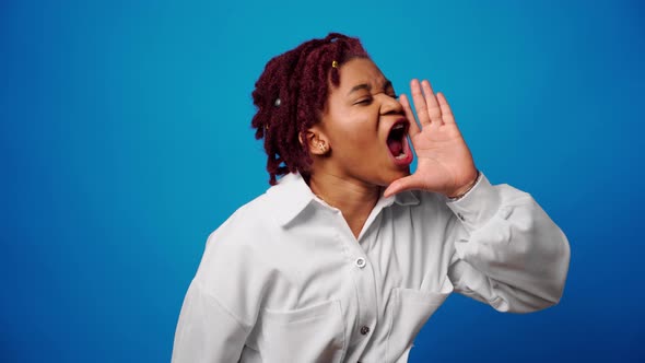 Young Afro Woman Screaming Calling Someone Telling News Against Blue Background