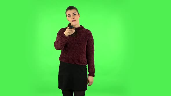 Woman with TV Remote in Her Hand, Switching on TV. Green Screen