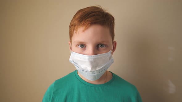 Portrait of Little Boy with Medical Face Mask Looking at Camera. Sad Male Child Wearing Protective