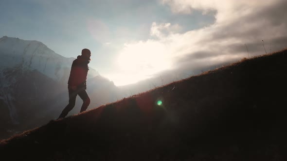 Aerial View of Epic Shot of a Man Walking on the Edge of the Mountain As a Silhouette in a Beautiful