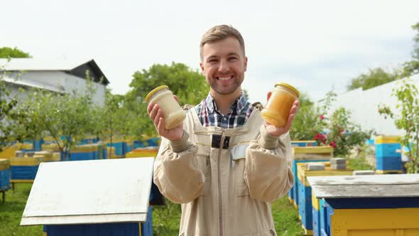 Portrait of Beekeeper with a Two Jars with Fresh Honey