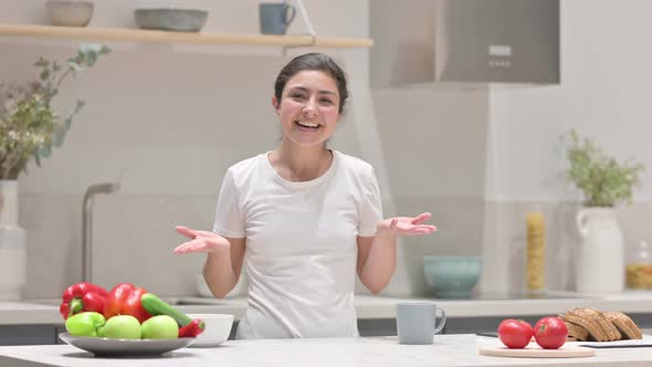 Young Indian Woman Doing Video Call While Standing in Kitchen